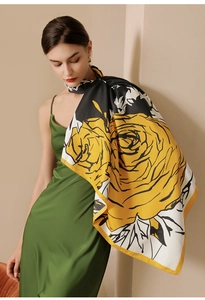 Detail of elegant satin scarf with yellow rose print draped over model's shoulders