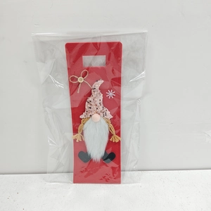 Detail of Christmas gnome wine bottle cover with sequin hat and white beard in red felt