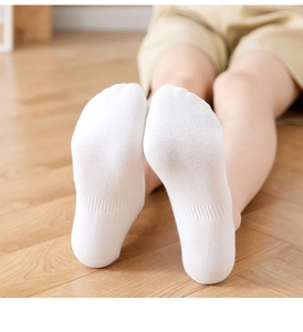 Close-up of white low-cut invisible cotton socks on feet featuring anti-slip design