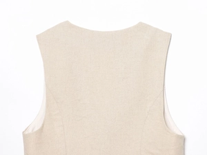 Gros plan détaillé de l'encolure et de l'épaule d'un gilet beige clair en coton et lin