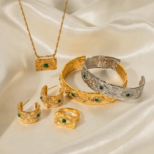 Lava style evil eye jewelry set with green stones on silk background for women