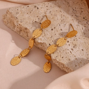 Gros plan sur les boucles d'oreilles pendantes ovales martelées en plaqué or