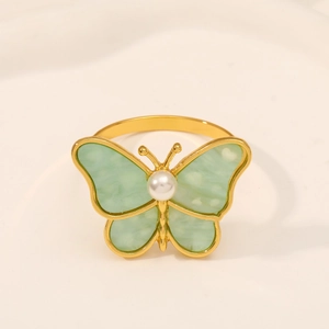 Detail of dragonfly napkin ring with light green wings and a white pearl body