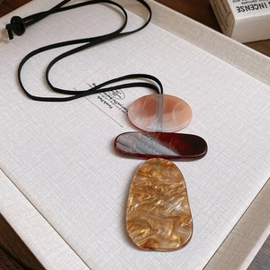 Artistic resin geometric pendant with marble texture on a black cord necklace