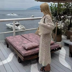 White bohemian crochet lace long sleeve maxi dress for women in a seaside setting