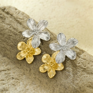Vue macro de boucles d'oreilles fleurs bicolores avec pétales texturés sur pierre