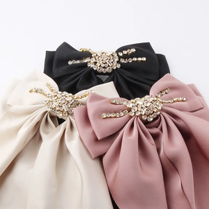Elegant satin bow hair clips with radiant rhinestone center in black, beige, and pink
