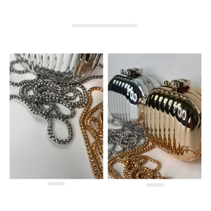 Detail of trendy metallic mini acrylic bags in gold and silver with wavy texture and chain