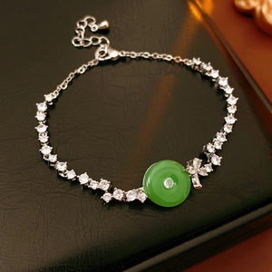 Detail of silver chain bracelet with green chalcedony stone and zircon inlay on black leather