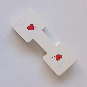 White cardboard jewelry display cards featuring red heart patterns for hair clips