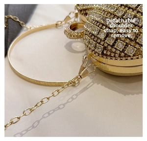 Detail of luxurious gold evening bag with rhinestones and detachable metal chain strap