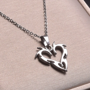 Macro shot of a silver gothic heart pendant with flame details on a jewelry box