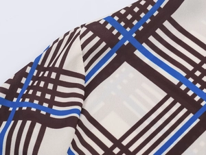 Detail of multi-color plaid fabric texture and shoulder stitching on a casual shirt