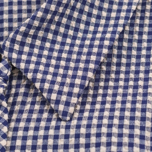 Vue macro détaillée de la texture et des coutures du col en seersucker vichy bleu et blanc