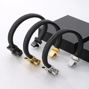Detailed view of woven leather bracelets with wolf head buckles in gold, silver, and black