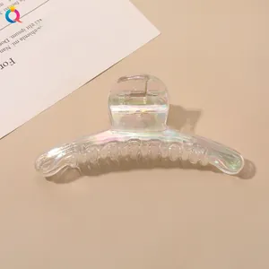 Macro view of large iridescent clear hair claw clip showing shiny rainbow finish