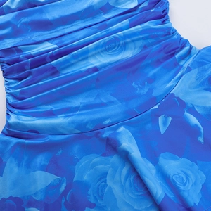 Détail de l'imprimé floral rose bleu sur tissu satiné froncé avec texture plissée élégante