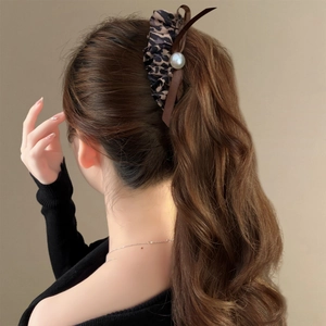 Maillard leopard print scrunchie with pearl and ribbon on a wavy ponytail