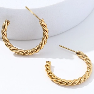 Polished golden 18K twisted rope C-shaped titanium steel hoop earrings on white stand