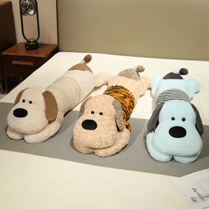 Trois coussins longs en peluche chien rayé pour dormir, en tissu doux sur un lit douillet