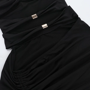 Detail of ruched black fabric with hollow cut-out design and gold metal buckle accent