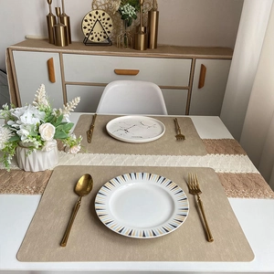 Elegant beige woven texture leather placemats with gold cutlery and ceramic plates