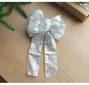 Silver glitter bow decoration with metallic texture on a rustic wooden table