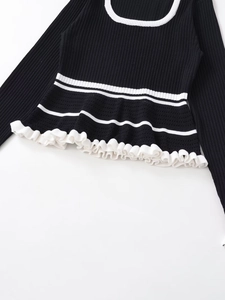 Close-up of contrast rib knit sweater with ruffled hem and white stripe detail