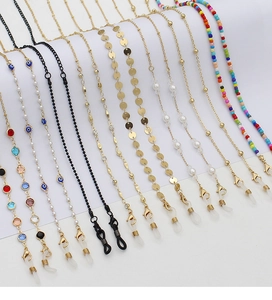 Detail of colorful beads and devil eye charms on bohemian glasses and mask chains