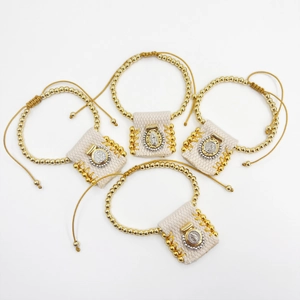 Religious woven bracelet set with golden beads, fabric pouches and icons on white background