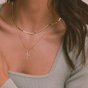 Close-up of double-layer gold plated snake chain necklace with zircon cross pendant