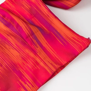 Detaillierte Makroaufnahme von rot-violettem Batikstoff mit glattem, verdecktem Reißverschluss