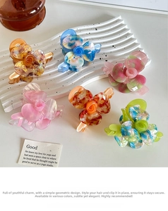 Detailed view of assorted acetic acid flower hair claws with elegant marble textures
