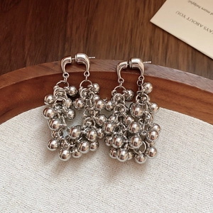 Boucles d'oreilles géométriques à glands avec sphères métalliques polies sur lin