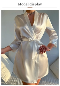 Detail of champagne satin robe with V-neck and self-tie belt under soft natural light