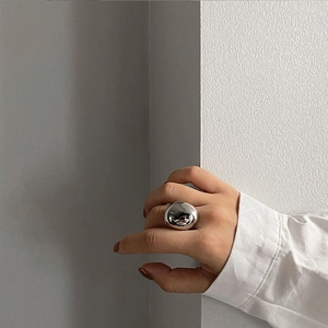 Close-up of a high-polish silver dome ring on model's hand with a minimalist design