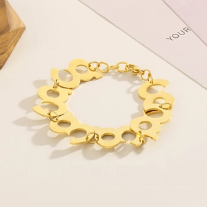 Detail of gold-plated stainless steel bracelet featuring geometric link patterns and clasp