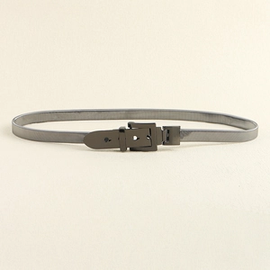 Close-up of a silver spring metal waist belt with a minimalist square buckle detail