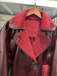 Close-up of burgundy faux leather jacket with red faux shearling lapel and soft fleece lining
