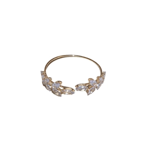 Elegant gold leaf open bangle featuring marquise cut rhinestones on a white background