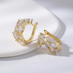 Détail macro de créoles en or rose ornées de zircons blancs étincelants en marquise