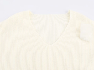 Detailansicht des cremefarbenen Strickpullovers mit V-Ausschnitt und weicher Textur