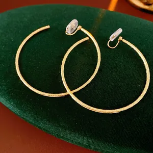 Orecchini a clip rotondi opachi placcati in oro con cuscinetti in silicone su velluto