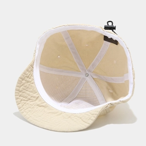 Detail of cotton lining and adjustable drawcord buckle on beige short-brim baseball cap