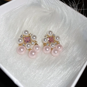 Detail of vintage gold earrings with pink gemstones and freshwater pearl charms