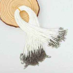 Bulk white cord necklace strings with metal lobster clasps and extension chains on wood
