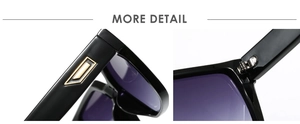 Close-up of black sunglasses featuring a golden metal logo inlay and durable hinge detail