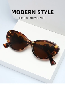 Detail of tortoise shell cat eye sunglasses with brown lenses on a white display stand