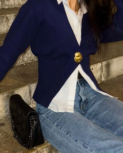 Dettaglio cardigan donna blu scuro con scollo a V e un grande bottone dorato di design