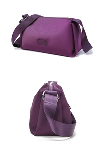 Detalle de bolso bandolera de nailon púrpura con correa ancha y herrajes plateados